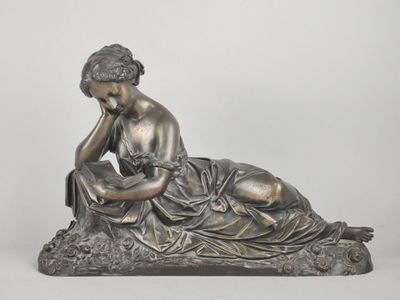 statue of a woman sitting on a rock with her hands on her face