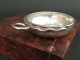 a silver bowl sitting on top of a wooden box