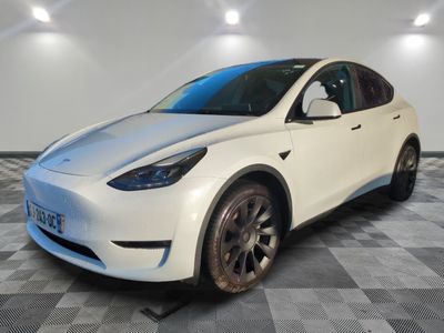 a white tesla suv parked on a checkered floor in a garage