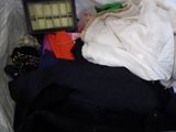 a pile of clothes in a trash can with a clock in it