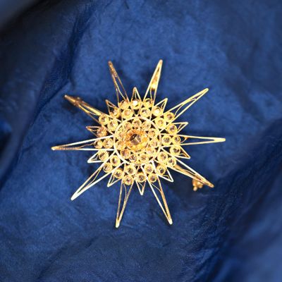 une étoile dorée rayonnante sur un tissu bleu