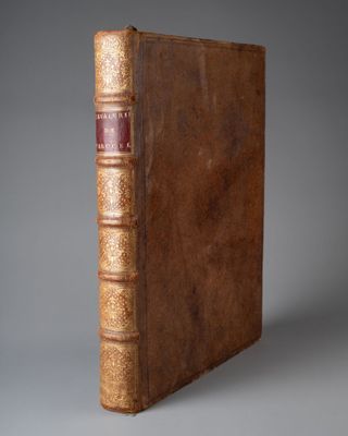 un vieux livre à la couverture brune posé sur une table