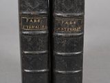 une paire de livres anciens en cuir noir posés l'un sur l'autre