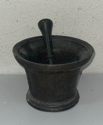 a black mortar and a black spoon in a black bowl