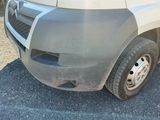 un camion garé sur un parking dont le sol est recouvert de terre