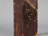 an old book sitting on top of a white surface