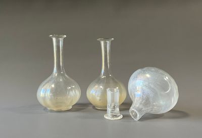 trois vases en verre posés l'un à côté de l'autre sur une table