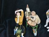 three figurines of people sitting on a chair