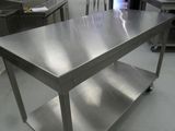 a stainless steel table in the middle of a kitchen