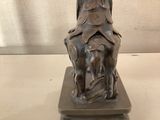 a statue of a woman sitting on top of a horse