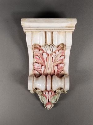 un gros plan d'un objet décoratif accroché au mur, sur fond gris