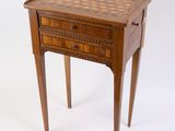 une petite table en bois sur laquelle est posé un échiquier