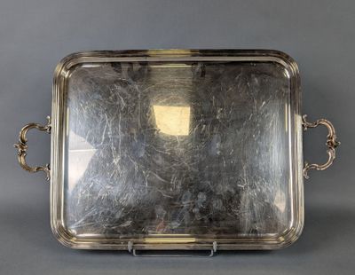 un plat ancien en argent avec des poignées, sur fond gris
