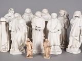 statue of a group of people dressed in white standing next to each other