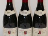 trois bouteilles de vin rouge sont alignées sur une table