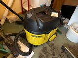 a yellow and black vacuum sitting on the floor in a room