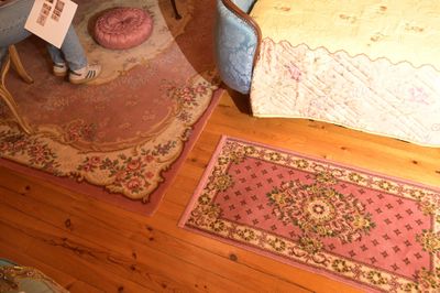 deux tapis posés à même le sol, à côté d'un lit, dans une chambre