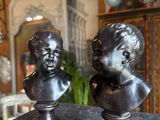 two statues of a boy and a girl sitting on a table