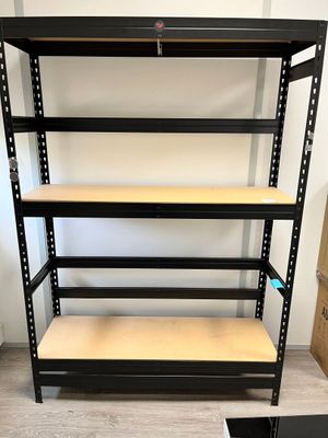 une étagère noire avec des tablettes en bois dans une pièce