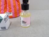 a bottle of liquid sitting on a table next to a bag