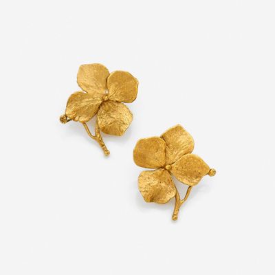 a pair of gold flower earrings on a white background