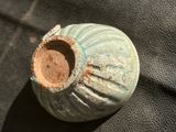 un petit vase posé sur un tissu noir