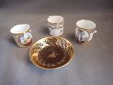 three cups and a saucer are sitting on a table