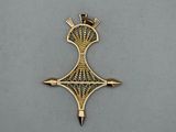 a gold cross with a crown on it sitting on a table