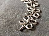 a close up of a chain with a bunch of scissors