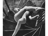 une photo en noir et blanc d'une femme nue allongée sur un escalier