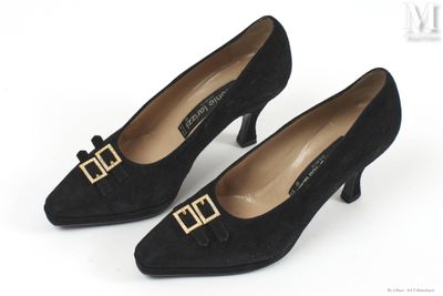 une paire de chaussures noires avec une boucle dorée au talon