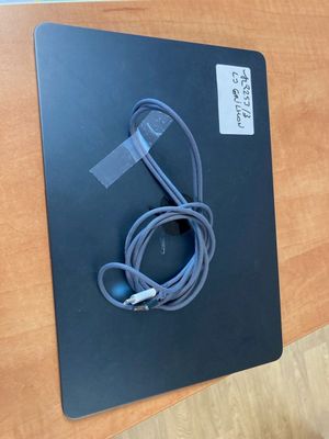 une image représentant une surface noire sur laquelle se trouvent un chargeur et un cordon d'alimentation