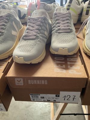 several pairs of running shoes are on a box in a store
