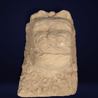 un gros plan sur une sculpture représentant un visage, sur fond bleu