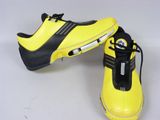 pair of yellow and black tennis shoes on a white surface