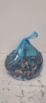 un sac en plastique rempli de pièces de monnaie posé sur un comptoir en marbre