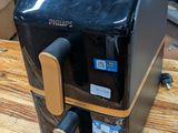 a black and gold coffee maker on a wooden table