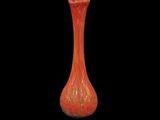 a red vase that is sitting on a black surface