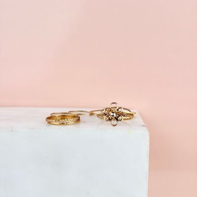 une paire de bagues en or posées sur un bloc de marbre