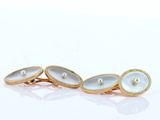 a close up of a pair of gold and pearl cufflinks