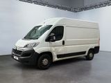 La camionnette blanche est garée dans la grande salle du bâtiment.
