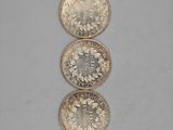 three silver coins sitting on top of each other on a table