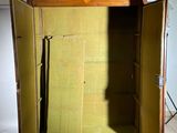 a wooden cabinet with a door open on a tiled floor