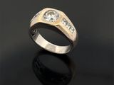 un gros plan d'une bague en or sertie de deux diamants sur un fond noir
