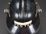 an old black fireman ' s helmet on a black background