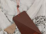 un gros plan d'une chemise blanche avec une étiquette marron