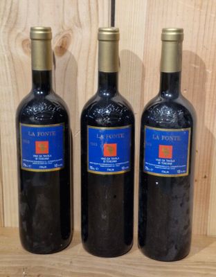 three bottles of wine sit on a wooden shelf in front of a wooden wall