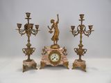 trois bougies et une horloge posées sur une table