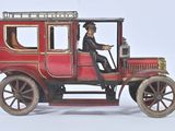 a red toy car with a man sitting in the driver ' s seat