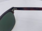 the glasses have green lenses on them on a white surface